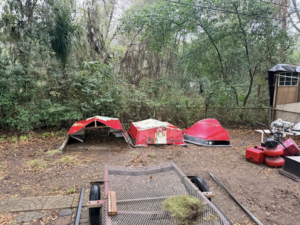 Several pieces of boat debris scattered in a yard, ready for junk removal by Won't Bash Your Trash in Savannah, GA.