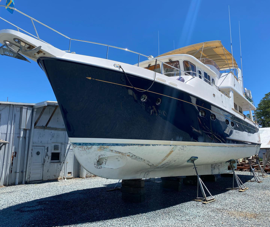 A large boat hull showing marine fouling before eco-blasting cleaning by Beach Eco Blasting in Virginia Beach, VA.