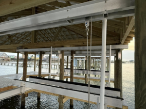 Close-up view of boat lift mechanisms installed under a covered dock by Payne's Marine Service, LLC in Fairhope, AL