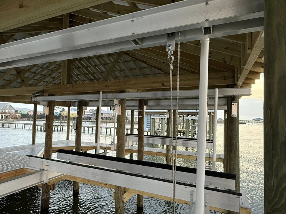 Close-up view of boat lift mechanisms installed under a covered dock by Payne's Marine Service, LLC in Fairhope, AL