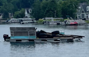 A boat on the water loaded with old tires and wood, indicating marine junk removal or cleanup near Flint, MI.