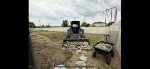 A bobcat loading broken concrete and pavers for a junk removal job by Haul My Load LLC in Caldwell, ID.
