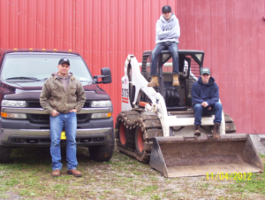 Team members with a Bobcat skid-steer loader and pickup truck for general contracting by Scott's Utica Junk Removal in New Hartford, NY.