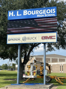 A boom lift being used for sign installation or repair at H. L. Bourgeois High School by B & H Metal Buildings Inc. in Kenner, LA.