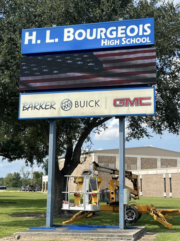 A boom lift being used for sign installation or repair at H. L. Bourgeois High School by B & H Metal Buildings Inc. in Kenner, LA.