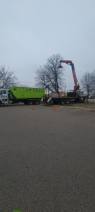 A boom truck efficiently loading tree debris into an Lp Tree Service trailer in Janesville, WI