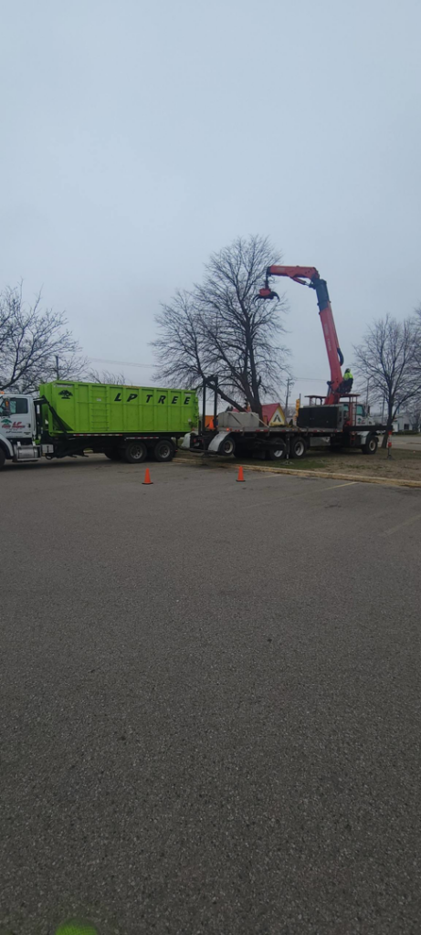 A boom truck efficiently loading tree debris into an Lp Tree Service trailer in Janesville, WI