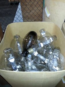 A box filled with various large light bulbs collected for recycling by Quick Light Recycling in South San Francisco, CA.