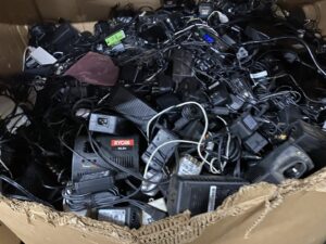 A box filled with power adapters and chargers, collected as e-waste by R3Ewaste in Phoenix, AZ