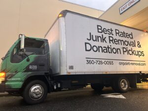 An OnPoint Removal Services box truck, advertising junk removal and donation pickups, parked at a loading dock in Vancouver, WA.