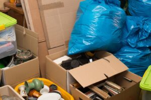 Cardboard boxes and blue trash bags filled with various items, ready for junk removal by Junk in the Truck LLC in Albuquerque, NM.