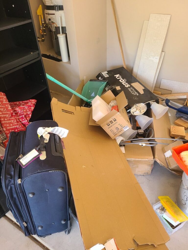 Boxes, luggage, and various items piled in a garage, ready for junk removal by Road Dogz Hauling in Las Vegas, NV.