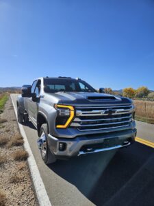 A white pickup truck loaded with branches and brush for yard waste removal by We R Trash Inc. in Loveland, CO
