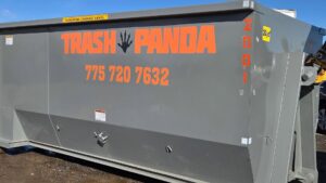 A gray 20-yard dumpster with the Trash Panda logo and contact information in Carson City, NV.