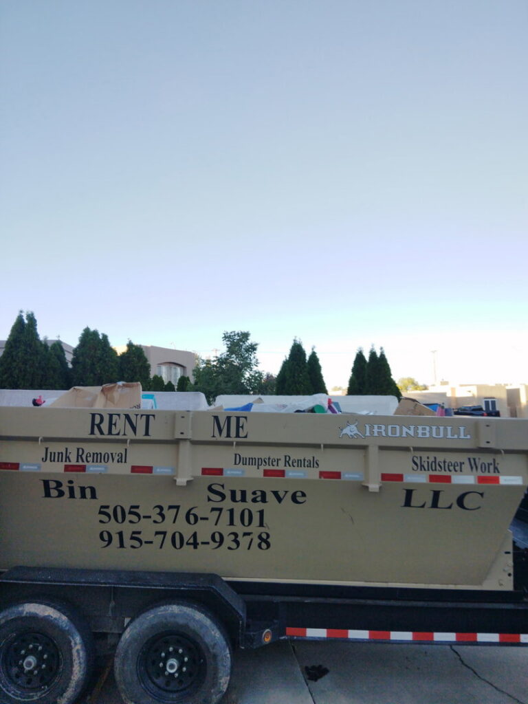 A Bin Suave LLC branded dump trailer advertising junk removal and dumpster rentals in Espanola, NM.