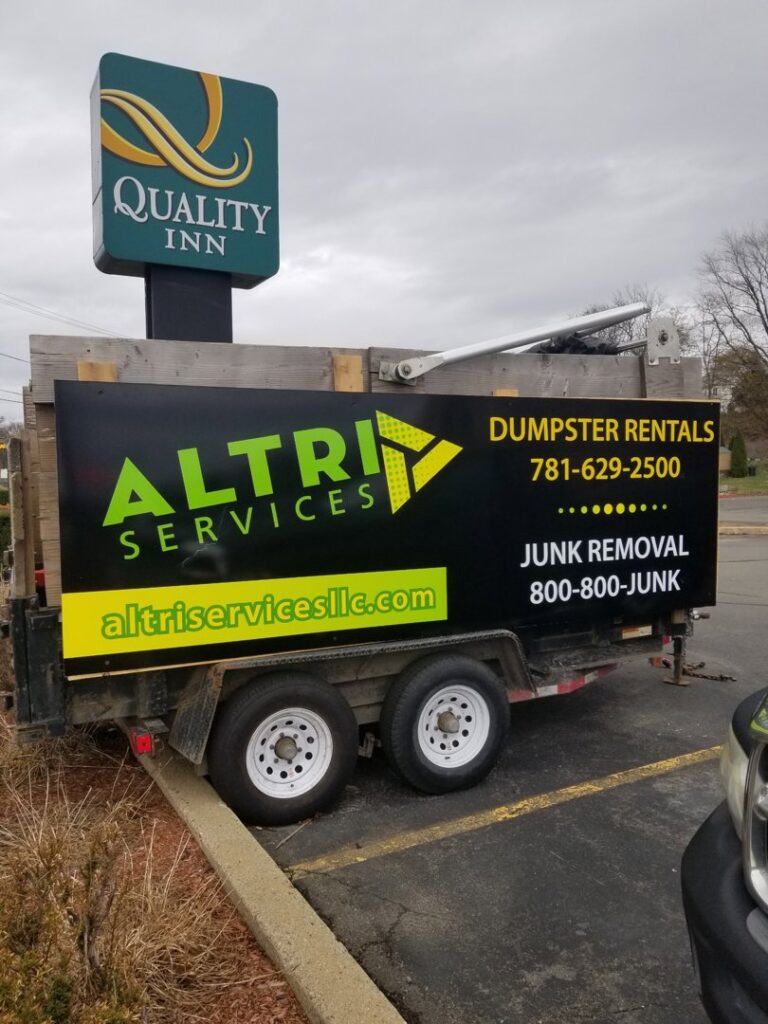 A branded trailer for Altri Junk Removal Services, offering dumpster rentals and junk removal in Lynn, MA.