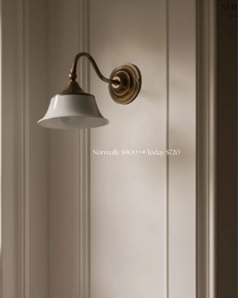 A classic brass and white wall sconce mounted on a paneled wall, demonstrating lighting installation by Wiersma Homes in Knoxville, TN.