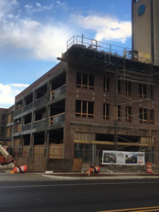 Exterior of a brick building undergoing renovation with scaffolding and boarded windows by Kemna Restoration & Construction in Indianapolis, IN.