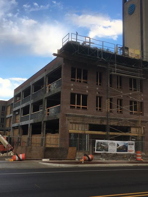 Exterior of a brick building undergoing renovation with scaffolding and boarded windows by Kemna Restoration & Construction in Indianapolis, IN.