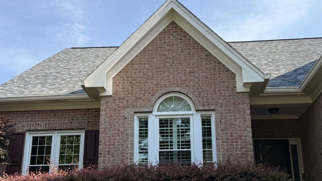 The front exterior of a brick house featuring new windows installed by NC Siding and Windows in Raleigh, NC