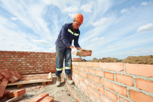 A handyman performing bricklaying and masonry work for a wall at Nail Builders, Inc. in Littleton, CO