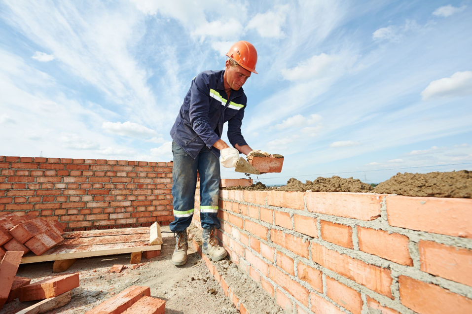 A handyman performing bricklaying and masonry work for a wall at Nail Builders, Inc. in Littleton, CO