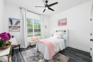 A bright bedroom interior with a single bed and modern decor, completed by Coastal Pointe Homes in Tampa, FL.