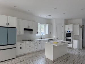A bright kitchen with new white cabinets and light countertops installed by Dahlman Construction in San Tan Valley, AZ.