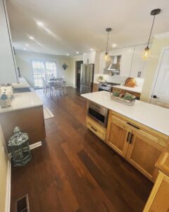 A bright kitchen remodel featuring an island, wood floors, and a dining area by Garrett Group Construction in Philadelphia, PA.