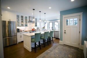 A bright kitchen remodel with white cabinets, stainless steel appliances, and a light blue accent wall, by Northrup Remodeling in Minneapolis, MN