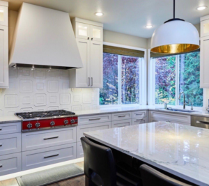 Bright kitchen with newly installed white cabinets, patterned backsplash, and countertops by Atlantic Tile & Granite in Kent, WA.