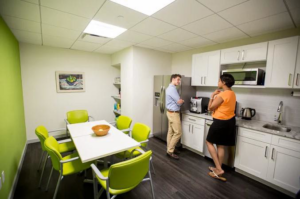 A bright office breakroom with new white cabinets and appliances installed by J. Forrest Development, LLC in Matthews, NC.