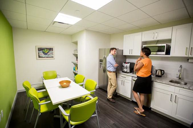 A bright office breakroom with new white cabinets and appliances installed by J. Forrest Development, LLC in Matthews, NC.