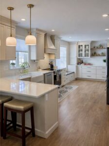 A bright white kitchen remodel with light cabinets, a large island, and pendant lighting by Pluff Contractors LLC in Lancaster, PA.