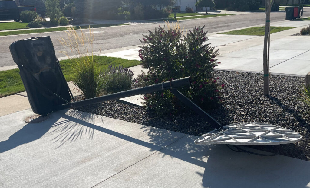 A broken basketball hoop lying on the ground, ready for Junk Holler to remove in Boise, ID.