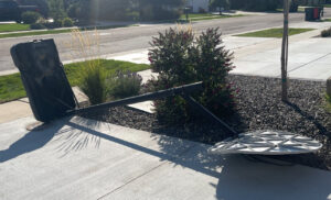 A broken basketball hoop lying on the ground, ready for Junk Holler to remove in Boise, ID.