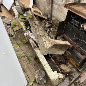 Broken concrete pieces, dirt, and old equipment piled up for removal by DLS Junk Removal in Waterbury, CT.