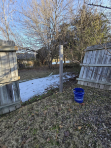 A broken wooden fence with a single post standing, indicating fence repair preparation by Creekside Handyman NWA in Centerton, AR.