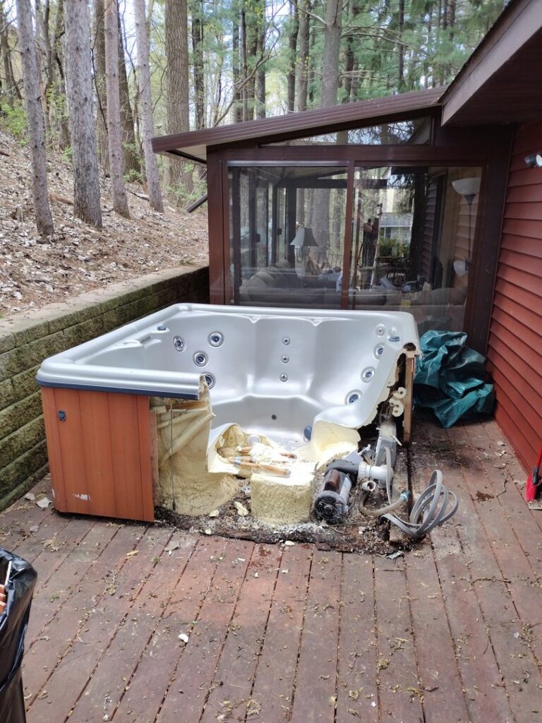 A broken and dismantled hot tub on a wooden deck awaiting removal by One Call Junk Removal in Minneapolis, MN
