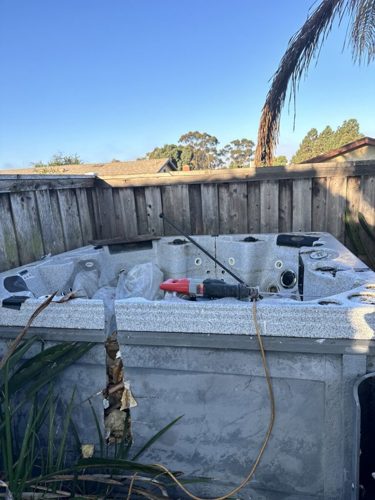 A broken hot tub in a backyard awaiting removal by Johan's Junk Removal and Hauling in San Diego, CA