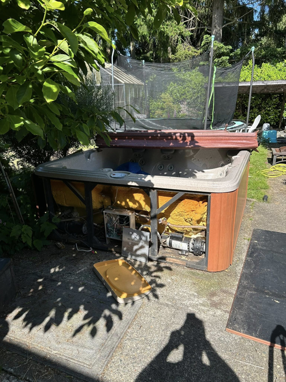 A broken hot tub in a backyard awaiting removal by Grit City Junk llc in Tacoma, WA.