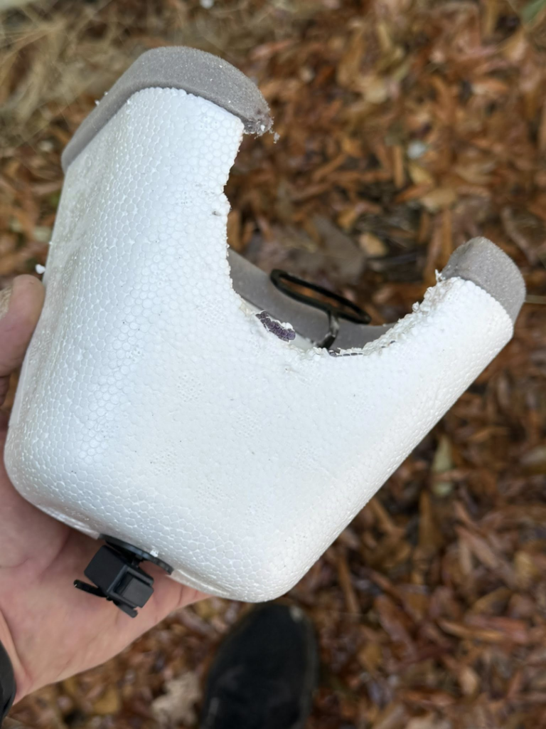 A broken piece of pipe insulation being held, indicating a potential repair job by Helms Plumbing and Drains in Charlotte, NC.