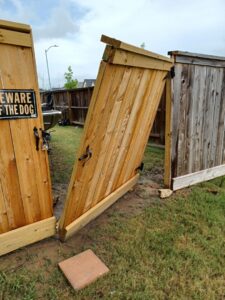 A broken wooden fence gate in need of repair, a service offered by Luis handyman service in Albuquerque, NM
