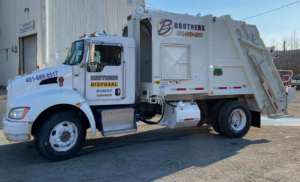 A white Brothers Disposal, LLC junk removal truck parked in Cumberland, RI, ready for service.