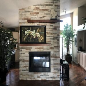 A brown stucco house with stone accents and a tile roof by Greg Unseth Painting & Exteriors in Colorado Springs, CO