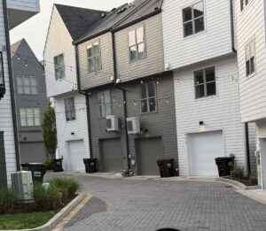 Brown trash bins provided by J.E. McMurtry Disposal & Recycling lined up in front of townhouses in Nashville, TN.