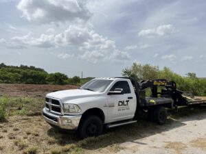 Piles of cleared brush and debris in the background of a prepared site, demonstrating land clearing services by DLT Land Management in Tampa, FL.