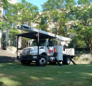 A white bucket truck, essential for tree trimming and removal, used by Quality Tree Care, Inc. in Pleasant Hill, CA.