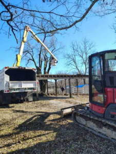 A bucket truck and wood chipper equipment used for tree trimming by Ortiz Tree Service in East Ridge, TN.