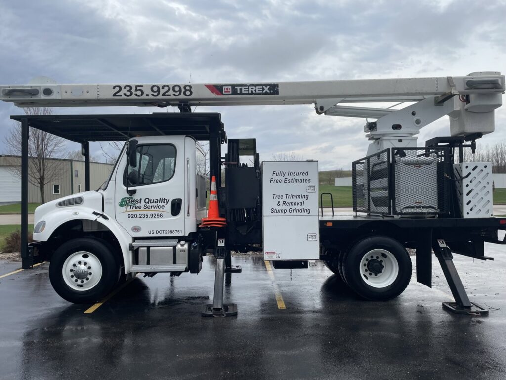 A Best Quality Tree Service bucket truck advertising tree trimming, removal, and stump grinding in Oshkosh, WI.